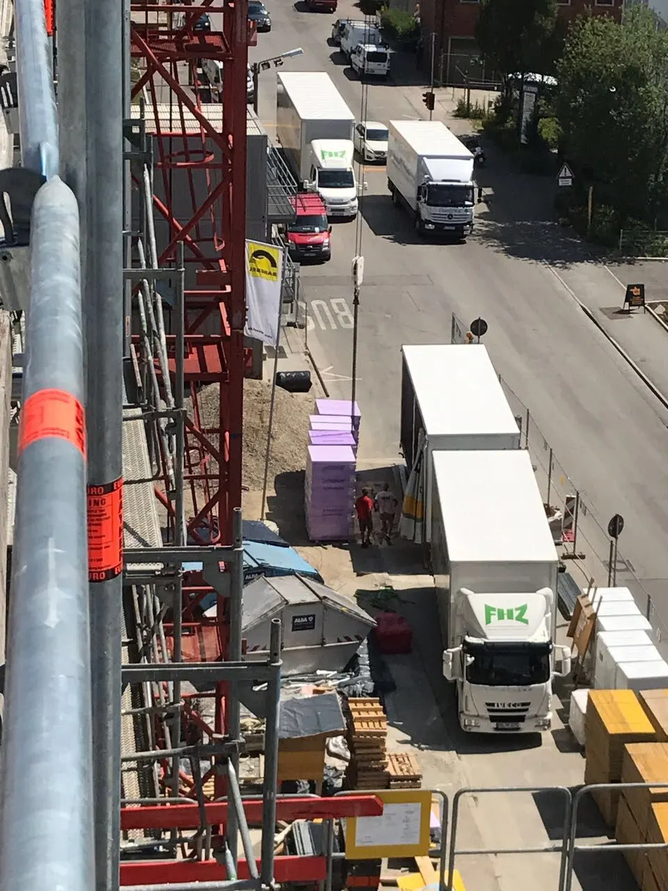 Blick vom Gerüst auf FHZ-Lkw und Baustellenverkehr in einer Straße