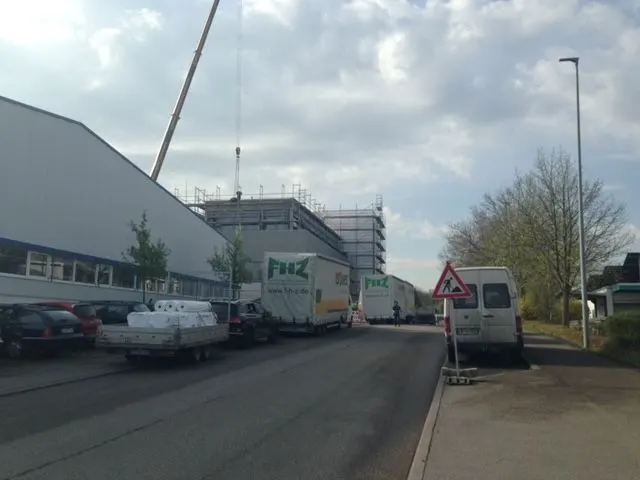FHZ-Lkw vor einer Gewerbehalle mit Baukran