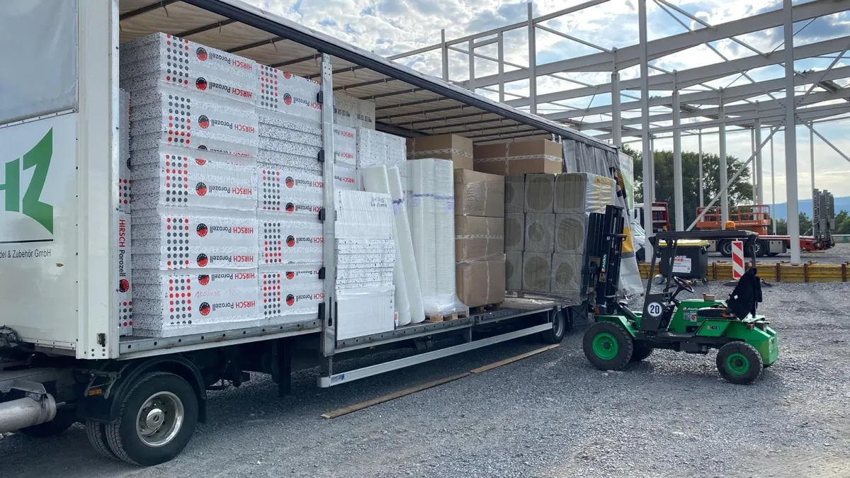 FHZ-Lkw und Mitnahmestapler an einem Hallenneubau mit Stahlskelett